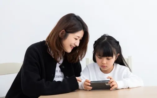 スマートフォンを見る親子